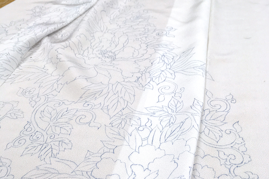 Tracing the design on the paper onto the fabric